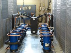 Wnętrze agregatu wody lodowej chłodzonego powietrzem typu MULTIPOWER wyposażonego w zespół sprężarek spiralnych (scroll ) oraz wymiennik płytowy